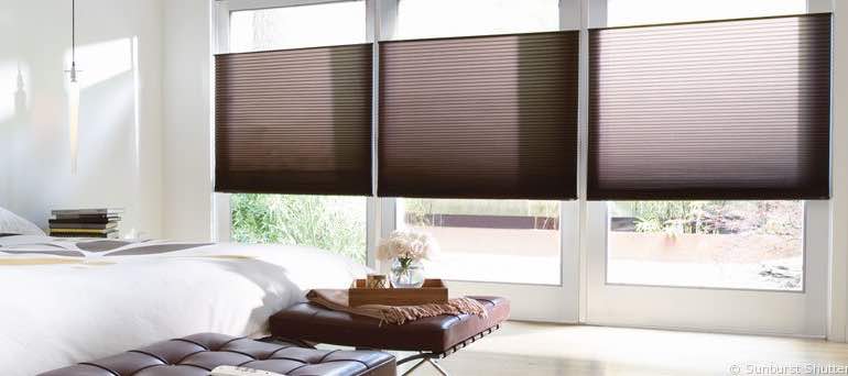 Trendy Bluff City bedroom with high windows and vertical honeycomb shades.