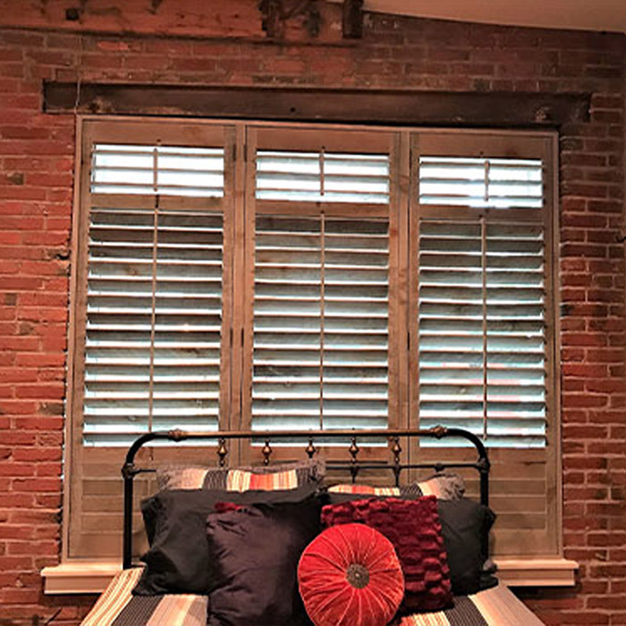 Reclaimed wood shutter windows of three different rooms of a house.