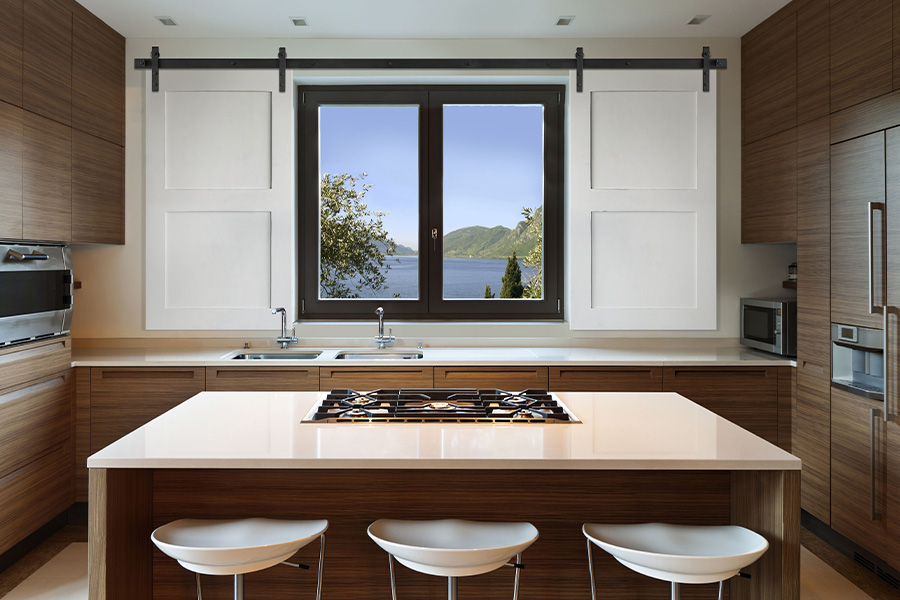 White farm house style barn door shutters above a kitchen sink.