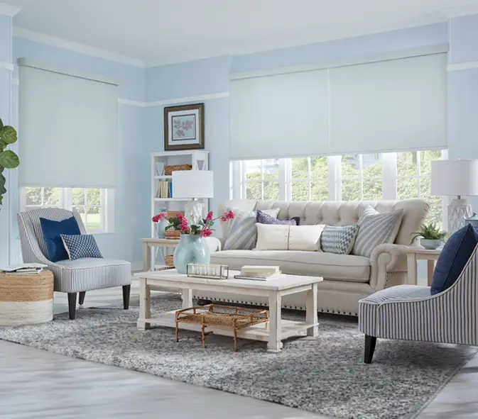 gray roller shades on large living room windows with dark blue and light blue decor