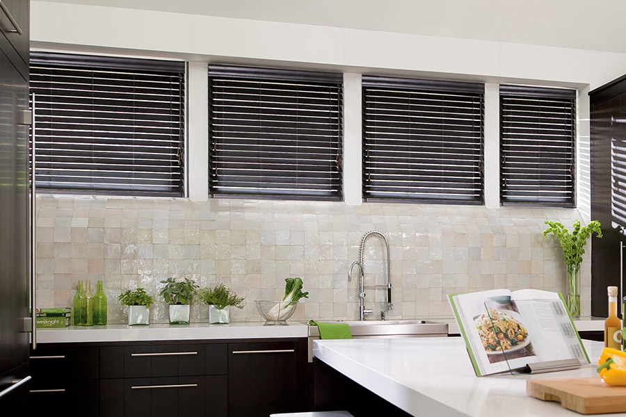 Choose custom Polywood faux wood blinds for your kitchen in Bluff City. Special shaped faux wood blinds in several windows above a sink.