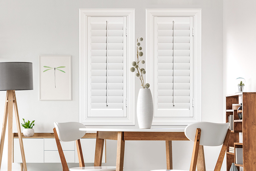 Sunburst's selection of stylish window treatments for designers in Bluff City makes it easy to find the perfect ones for every design job.  White Polywood shutters on two windows in a modern Scandinavian-style room