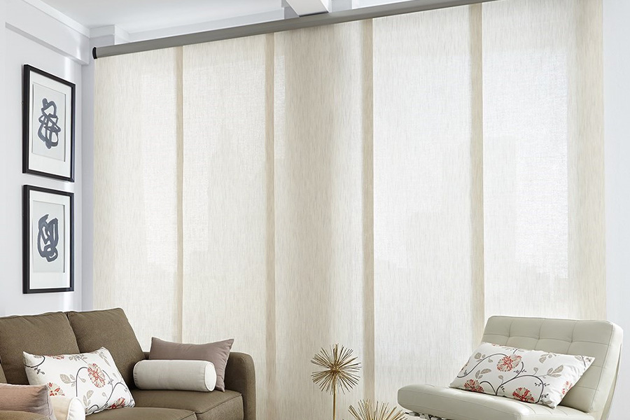 Find window treatments to complete any interior design among our extensive selection at Sunburst Shutters NE Tennessee.  Long off-white window shades on a tall window in a modern living room