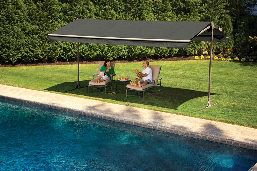 The combination of a pool and shade turns your backyard into the ultimate summer hangout. A couple lounging under a freestanding awning next to a backyard pool