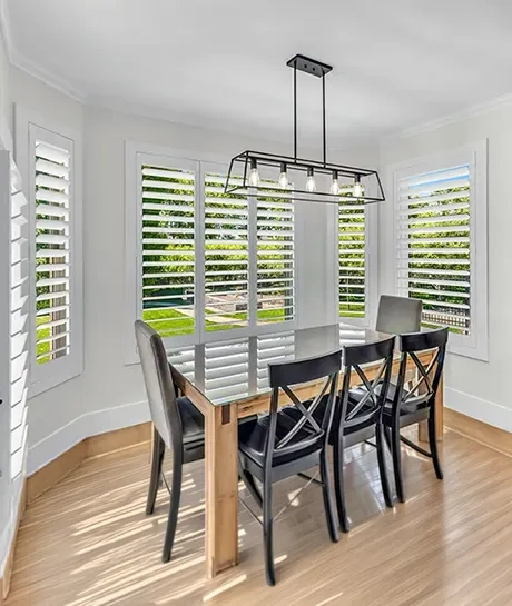 white polywood shutters within a bay window area with a breakfast nook